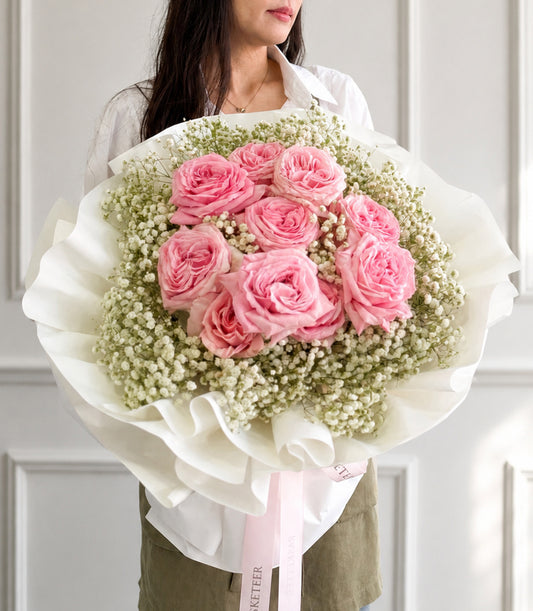 Luxurious Basketeer bouquet featuring vibrant pink O'Hara roses nestled among delicate baby
