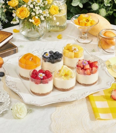 Mini cheesecake cups with Biscoff base and fresh fruit toppings on ornate serving tray