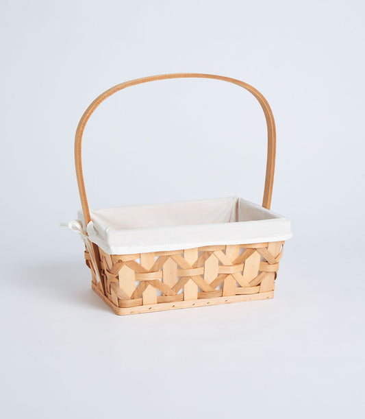 Light woven rectangular basket with tall handle and cream fabric lining, ready for luxury gift curation