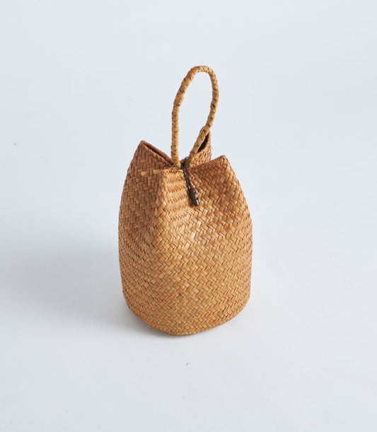 Handcrafted natural straw gift basket with rope handle and wooden toggle closure