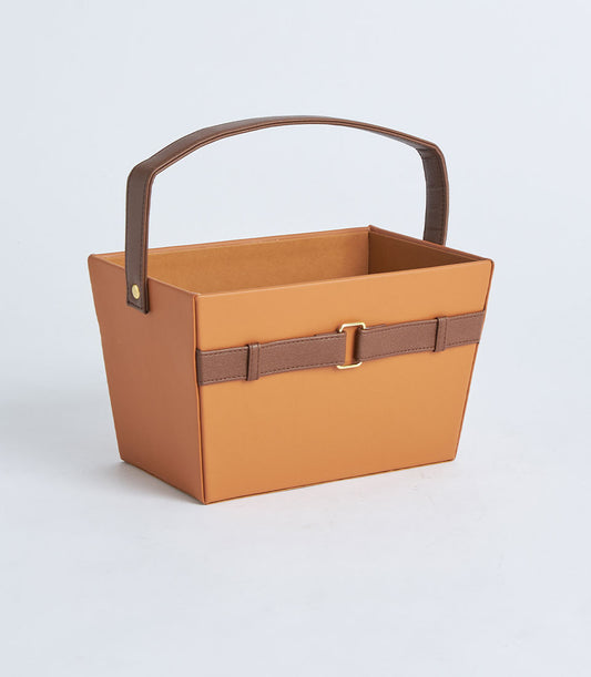 Tan leather gift basket with dark brown handle and gold buckle detail