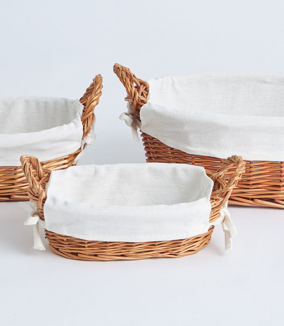 Natural wicker gift baskets with removable white linen liners in three sizes