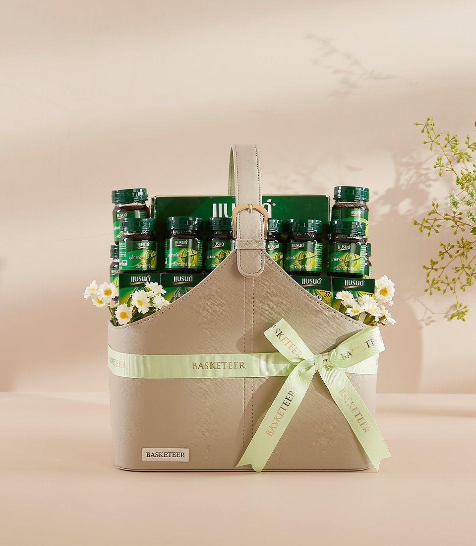 Serenity green bottle gift hamper in taupe leather basket with gold buckle and white flowers