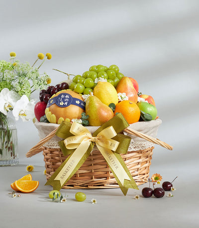 Premium wicker fruit basket with fresh grapes, pears, apples, and oranges, tied with cream ribbon