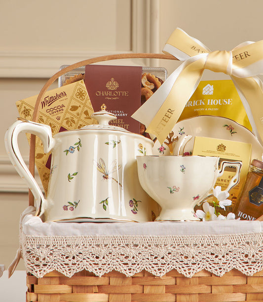 Cream ceramic tea set with floral motif in woven basket, paired with Earl Grey tea, chocolates, honey, and cashews for New