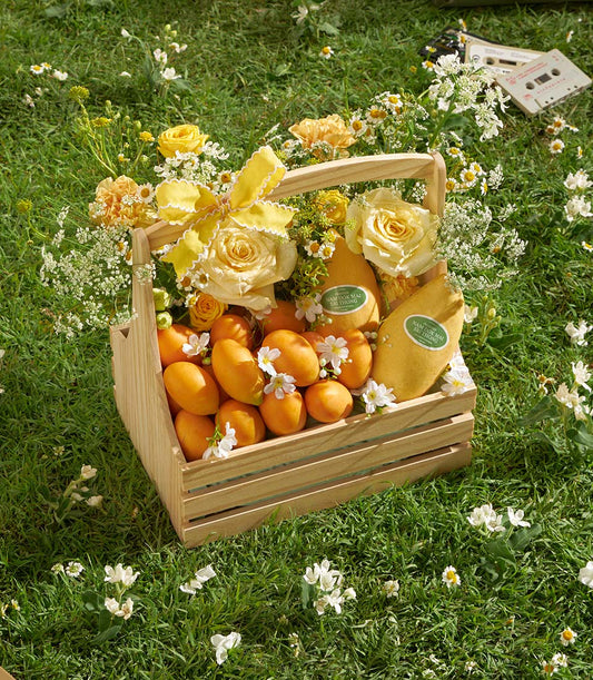 Premium mango and roses wooden basket with fresh tropical fruit and yellow blooms
