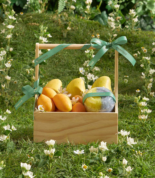 Wooden gift box filled with fresh mango, mayongchid fruit and sticky rice with green Basketeer ribbons