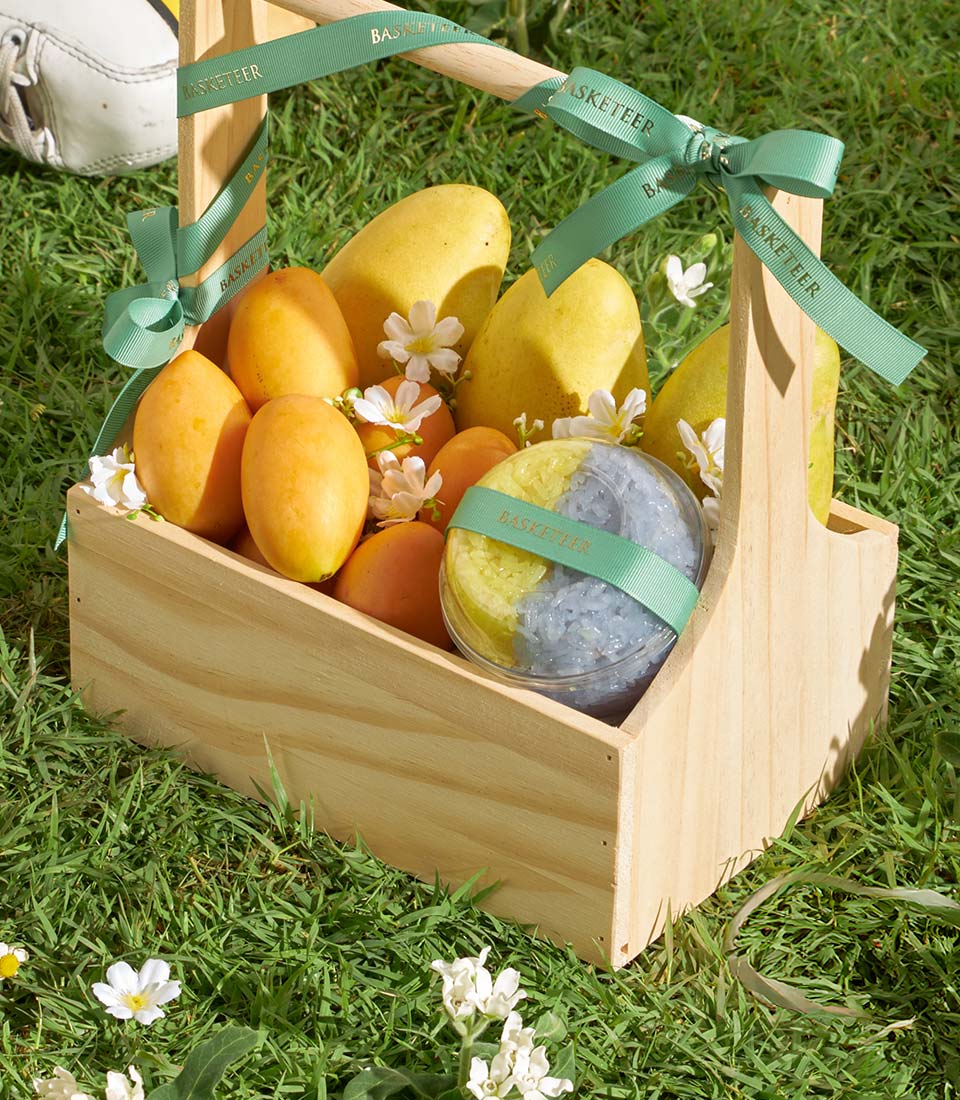 Premium mango and sticky rice wooden gift basket with tropical fruits and white flowers