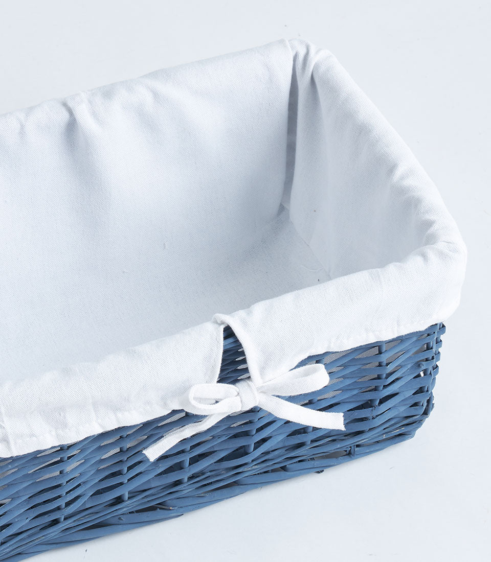 Navy wicker gift basket with white fabric lining and bow