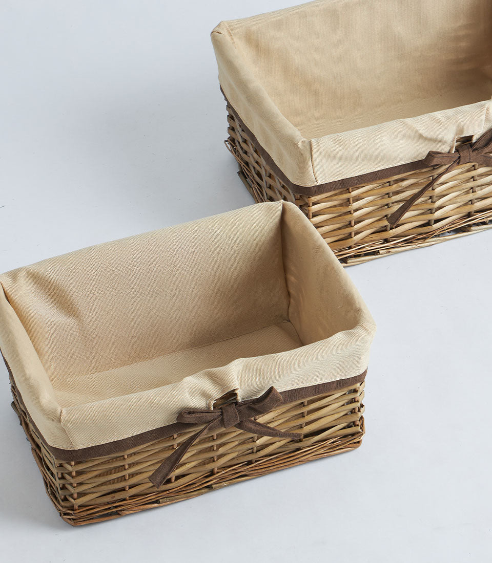 Natural wicker gift baskets with beige fabric linings and brown ribbon bows