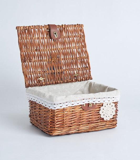 Handwoven rectangular wicker storage basket with hinged lid, natural brown weave, beige floral fabric lining, white lace