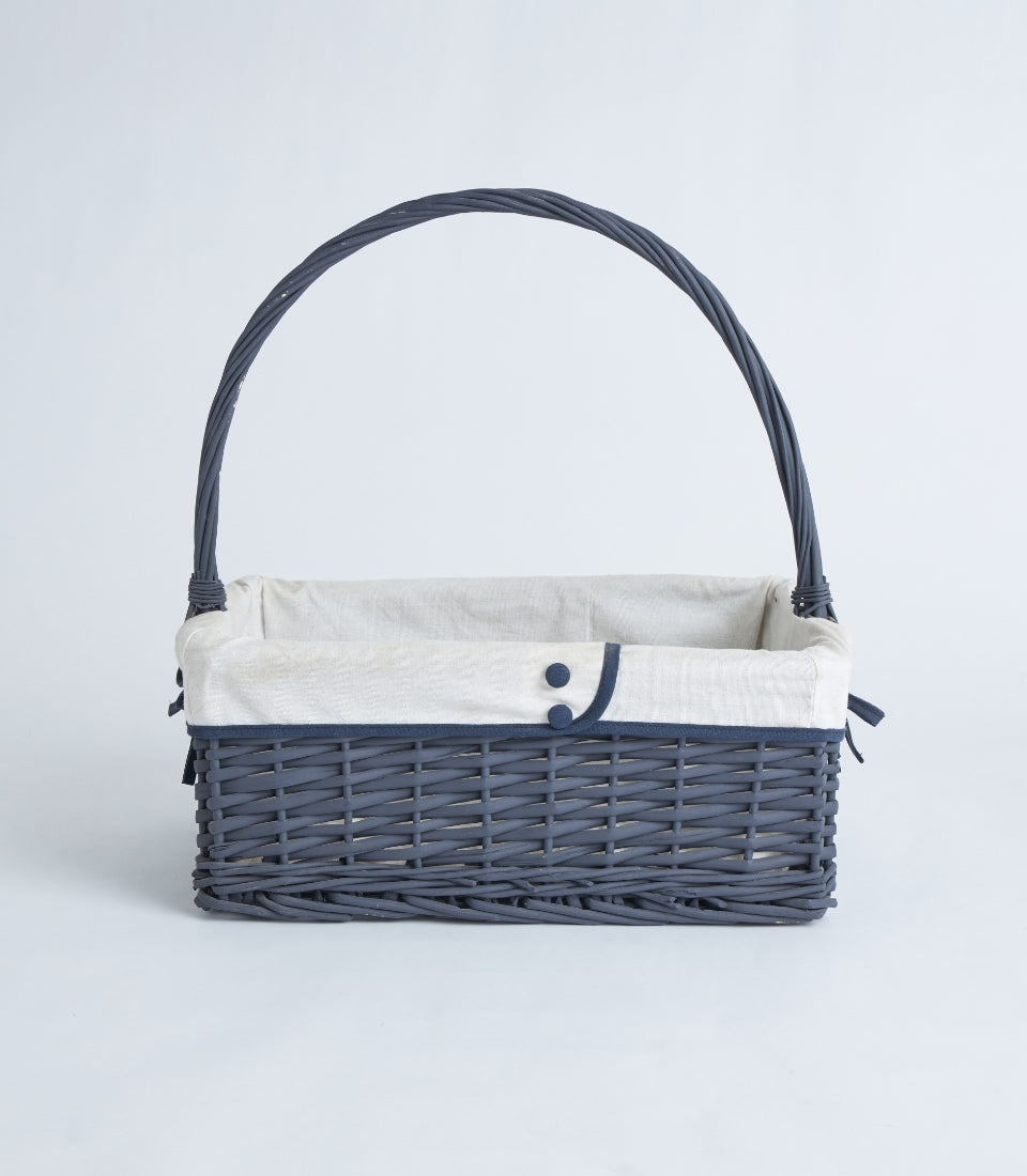 Navy wicker gift basket with beige liner and ribbon trim, arched handle