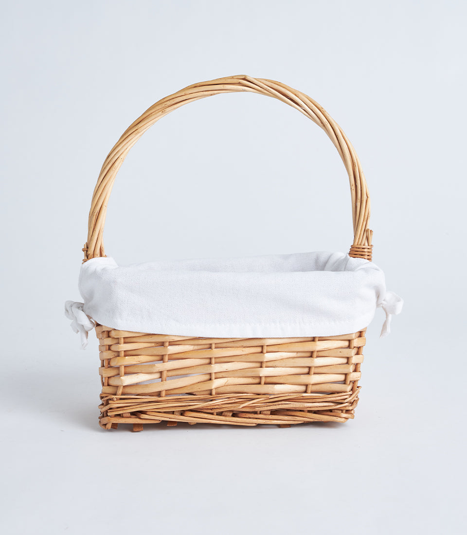 Natural wicker rectangular gift basket with white fabric lining and twisted handle