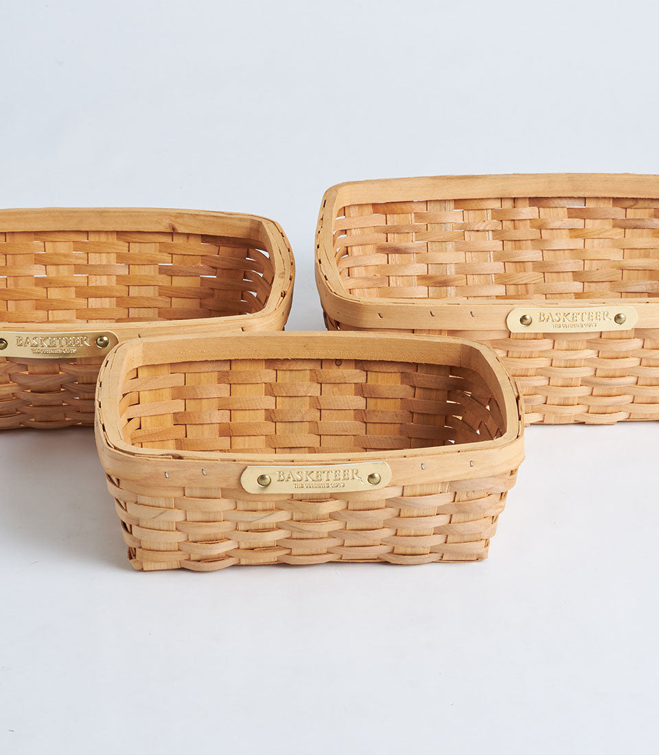 Natural woven bamboo oval storage baskets with brass Basketeer plaque, set of three nested sizes