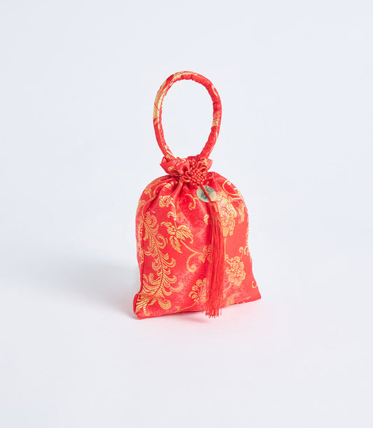 Red brocade fabric gift pouch with gold floral pattern, fabric handle, and decorative tassel charm