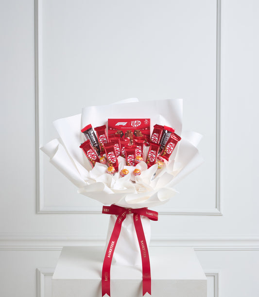 A luxurious Basketeer chocolate hamper bouquet featuring numerous Kit Kat bars and candies, elegantly