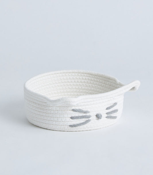 White cotton rope storage basket with playful cat face design and handles