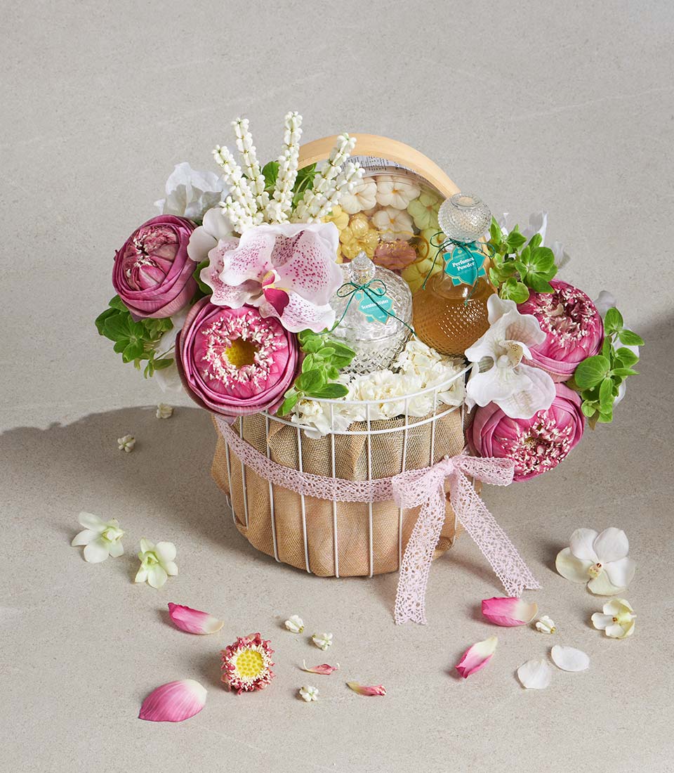 Pink lotus and orchid gift basket with scented water, perfumed powder, and flower-shaped confections