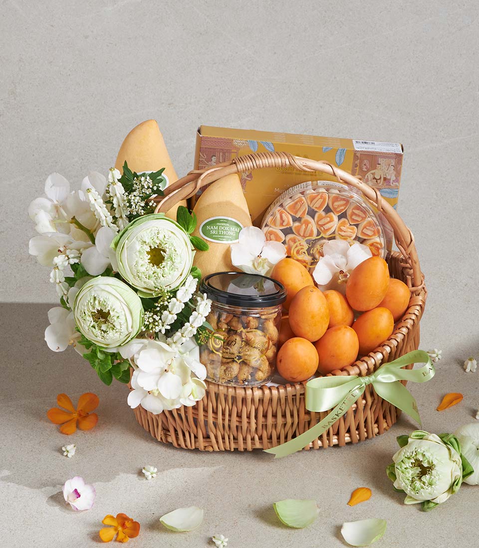 Luxury gift basket with fresh mangoes, gourmet treats, white orchids and lotus flowers, green satin ribbon