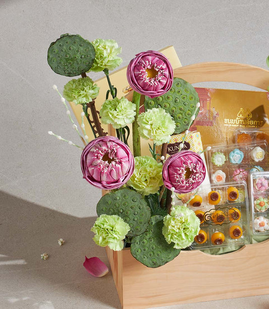 Pink lotus and green carnation gift basket with Thai desserts and golden treats