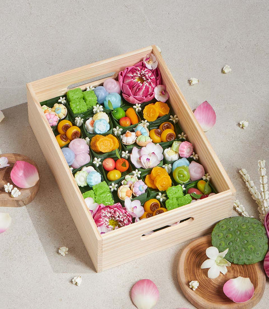 Thai lotus-inspired dessert box with colorful handcrafted sweets and fresh flowers, artisan gift hamper