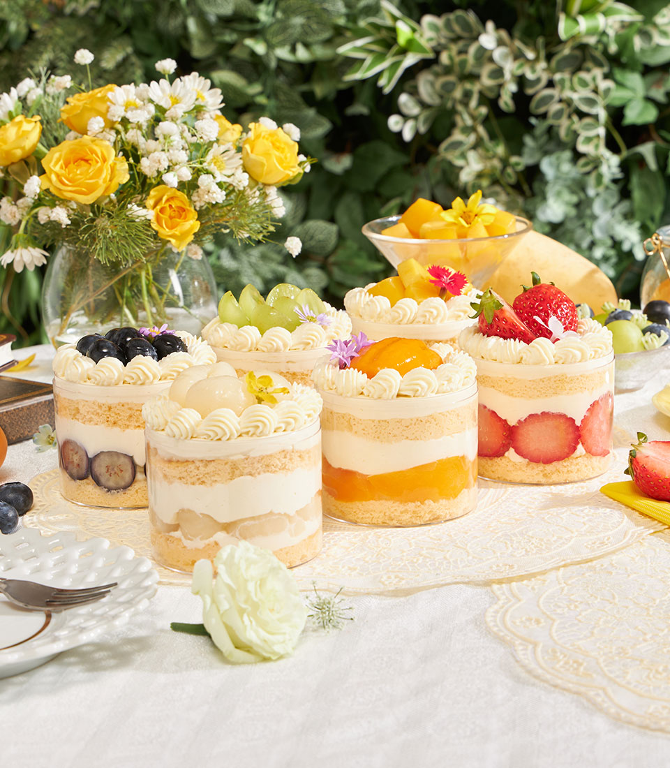Summer mini chiffon cakes with fresh cream, blueberries, lychees, and tropical fruits in individual servings