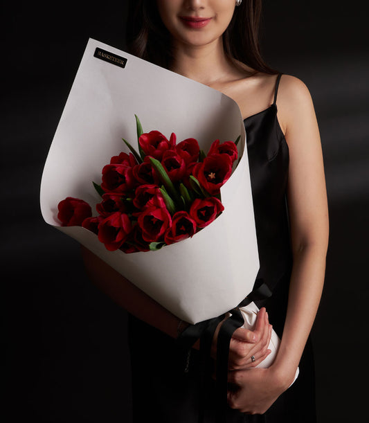Red tulip Valentine bouquet with white paper wrap and black ribbon