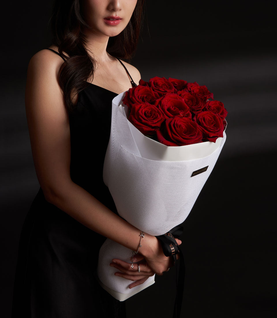 Lush red Explorer rose bouquet from Flowers by Basketeer, a premium flower delivery Bangkok. Wrapped in crisp white paper and tied with black ribbon.