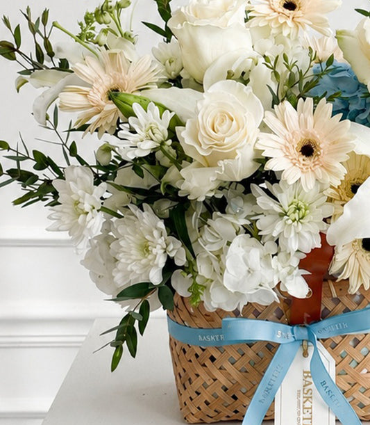 A luxurious flower delivery Bangkok basket arrangement featuring white roses, pale peach gerberas