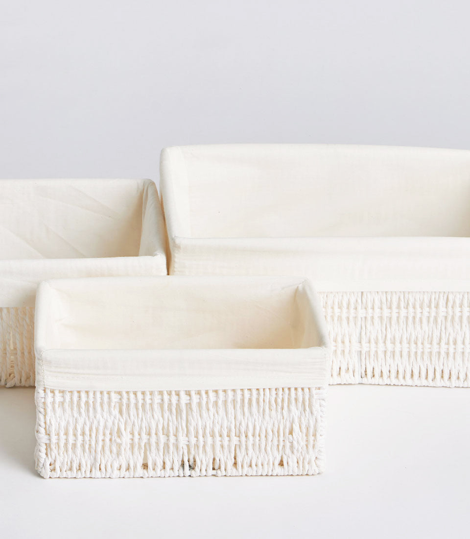 Cream handwoven wicker baskets with fabric lining in graduated sizes for storage and gifting