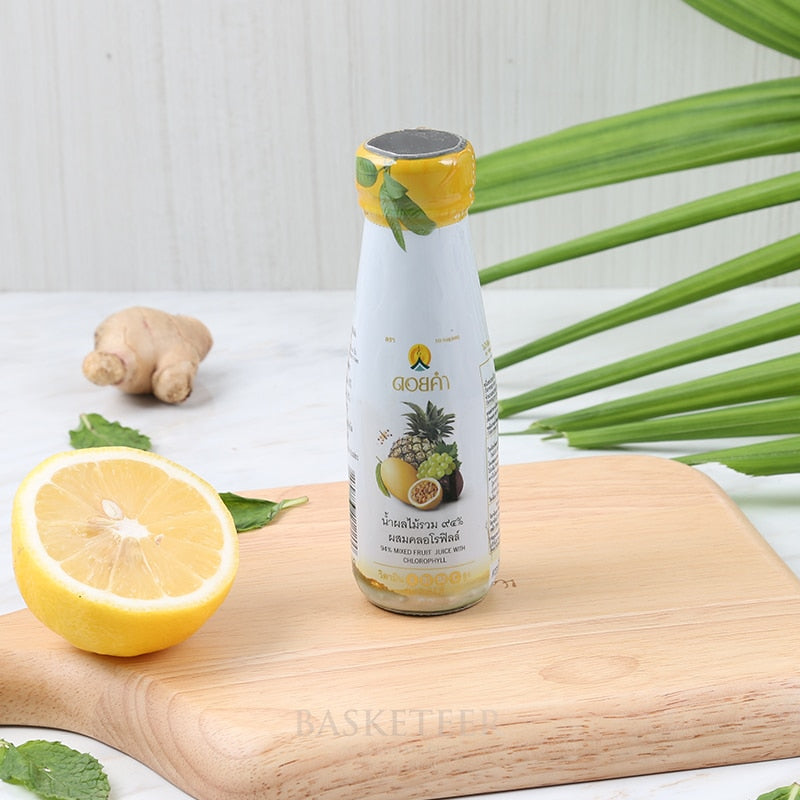 Mixed fruit juice with chlorophyll and natural ingredients in white bottle on wooden board with fresh citrus and mint