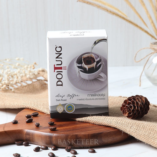 DoiTung dark roast drip coffee gift box with artisan packaging and scattered coffee beans on wooden board
