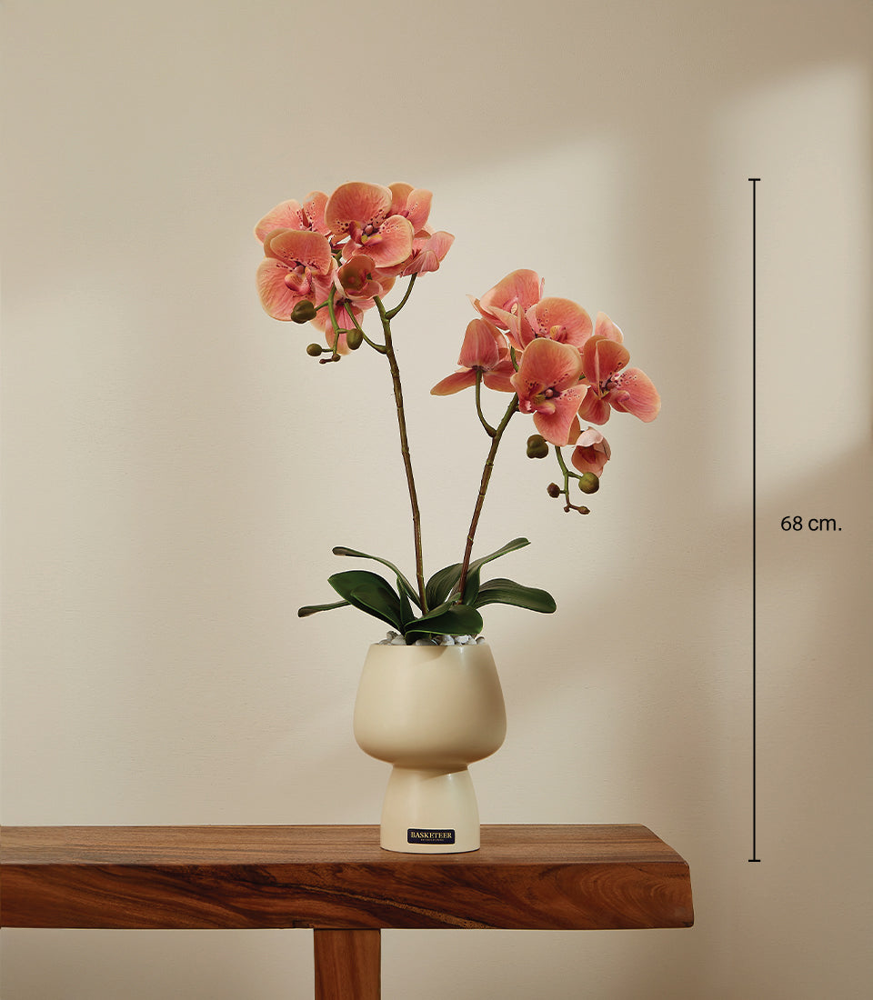 Faux coral-pink phalaenopsis orchid arrangement in cream ceramic vase with white pebbles, 68cm height