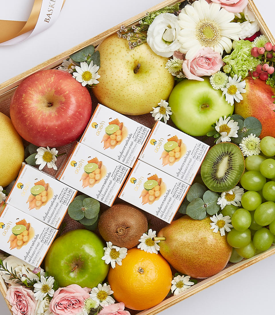 Wooden gift basket with fresh fruit assortment, ginger and wellness products, white daisies and pink roses