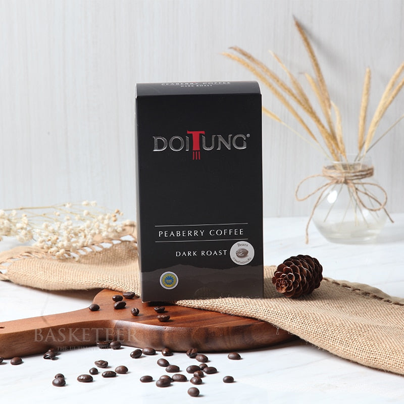 Dark roast peaberry coffee beans in black gift box with artisan presentation on wooden board