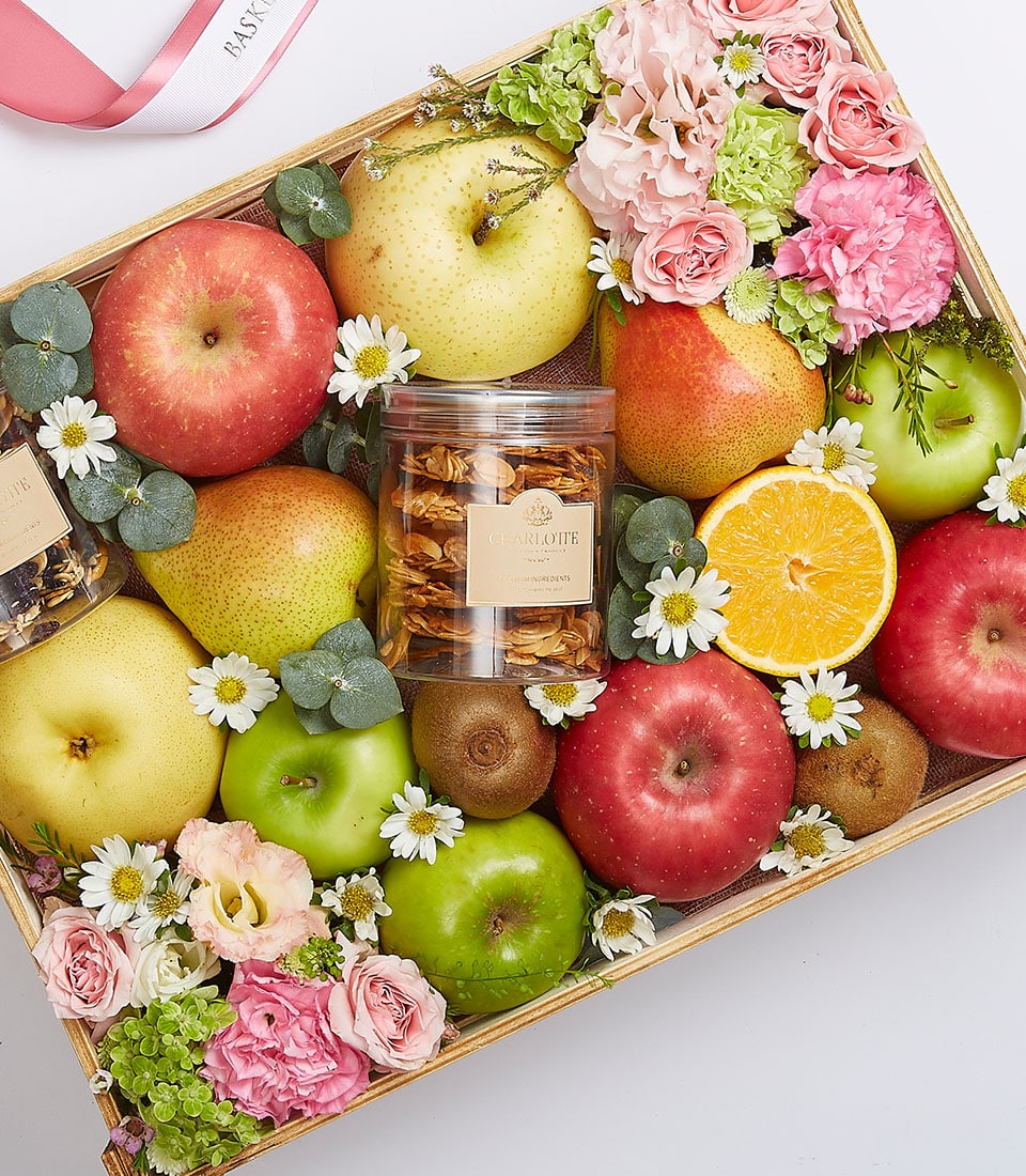 Exotic fruit gift box with apples, pears, kiwis, pink roses, carnations, hydrangeas, and gourmet snacks in wooden crate