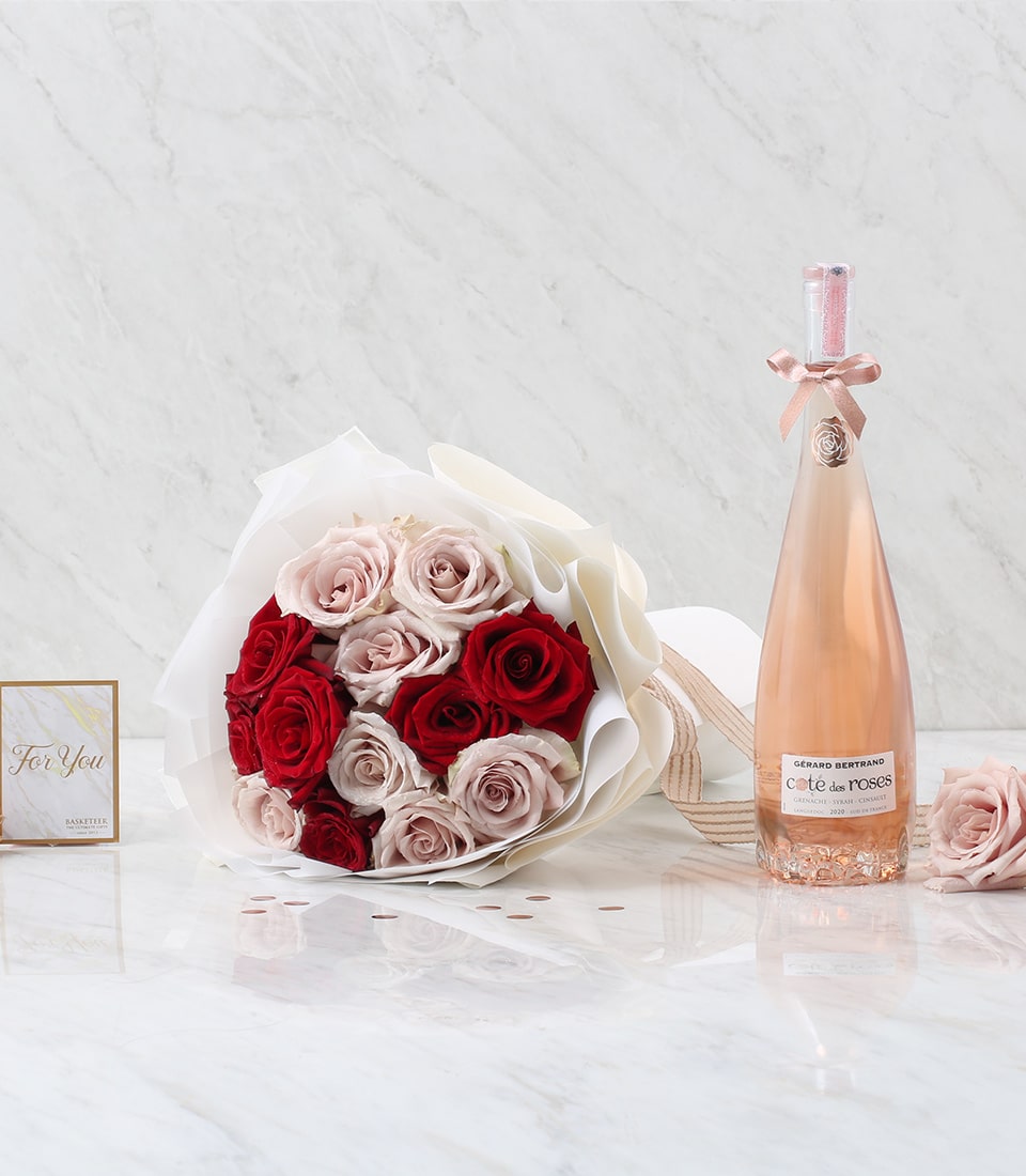 Romantic Rosé wine gift set with red and pink roses, white wrapping, and rose-shaped wine charm