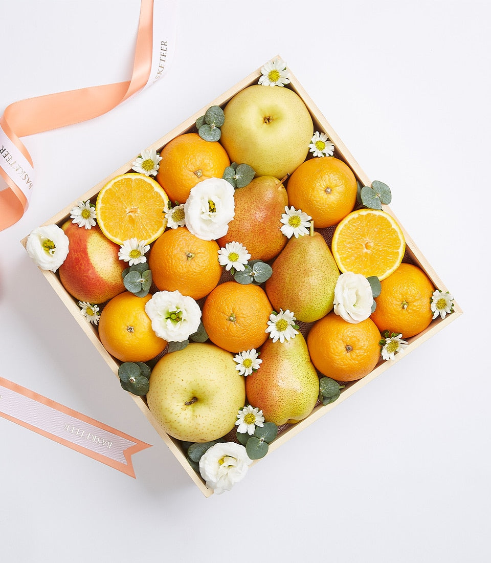 Wooden gift box with fresh oranges, apples, pears, white flowers and eucalyptus on burlap lining