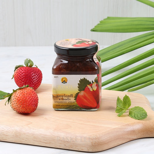 Premium Doi Kham strawberry jam jar with fresh berries and mint on rustic wooden board