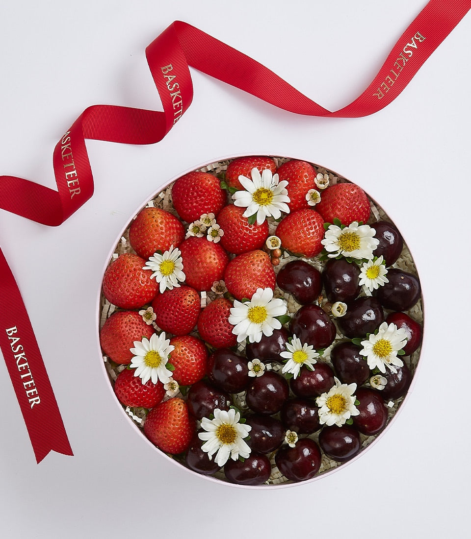 Sweet berry gift box with fresh strawberries, cherries and white daisies in pale pink packaging
