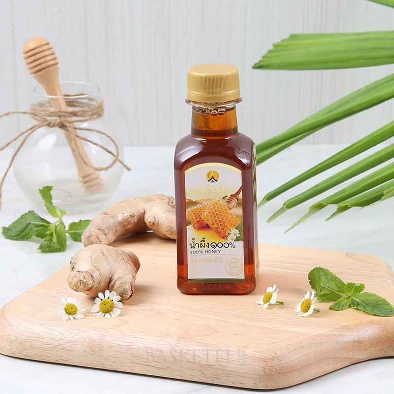 Premium Doi Kham pure honey with ginger root, fresh mint, and white flowers on wooden board