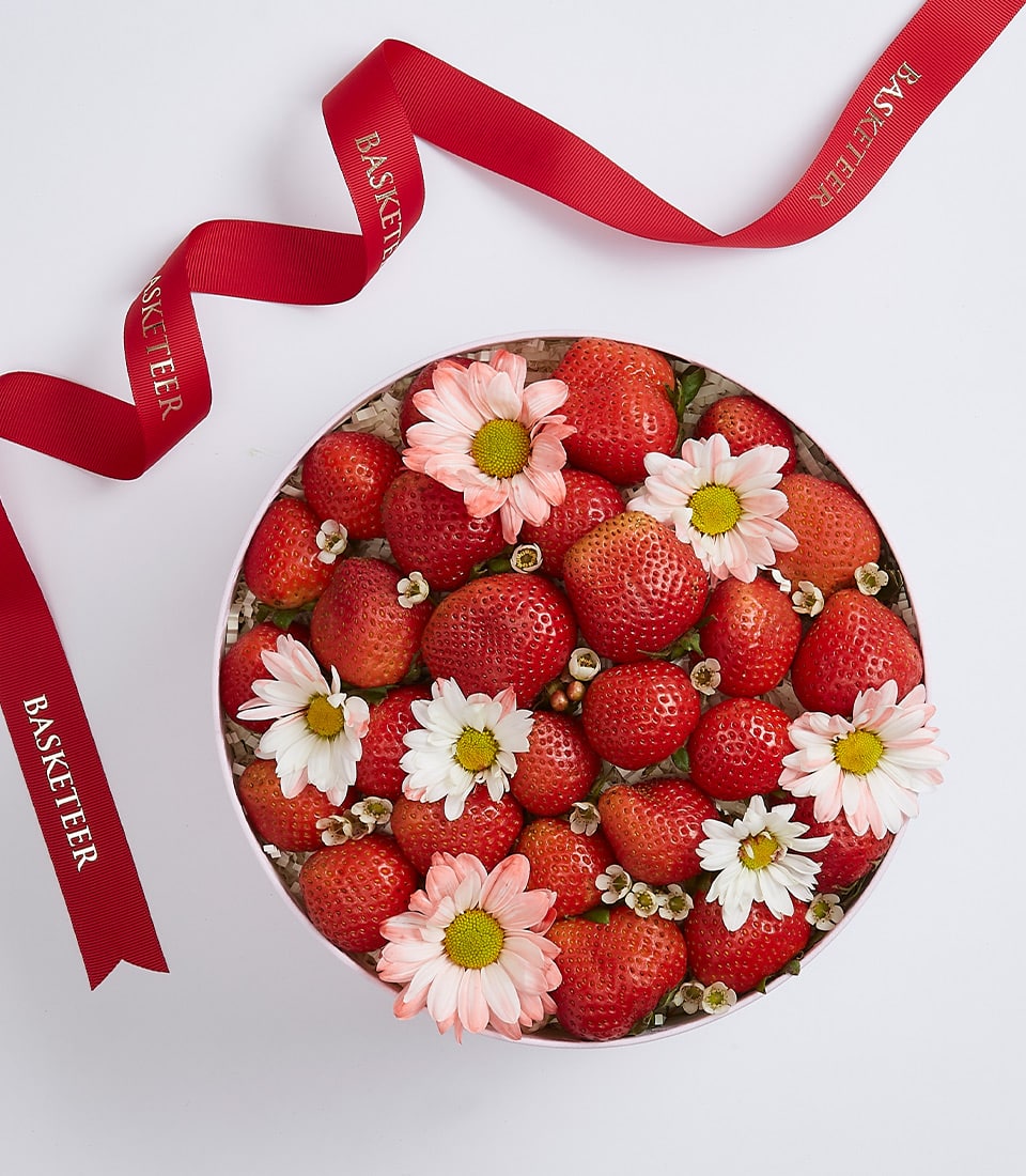 Fresh strawberries with white daisies in blush pink gift box, finished with red Basketeer ribbon