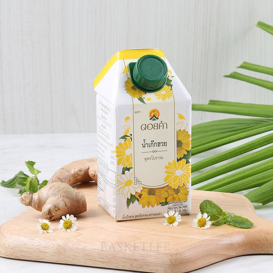 Traditional chrysanthemum tea carton with ginger, mint, and chamomile on wooden board
