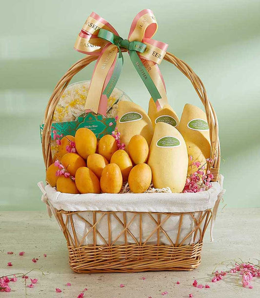 Tropical mango and sticky rice gift basket with woven wicker, pink flower petals, and Basketeer ribbon bow