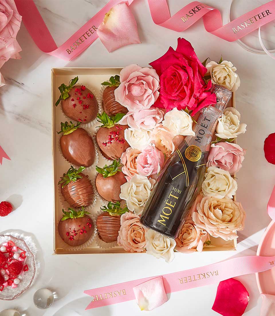 Luxury Valentine gift box with chocolate-covered strawberries, mini champagne, and premium fresh roses in pink and cream