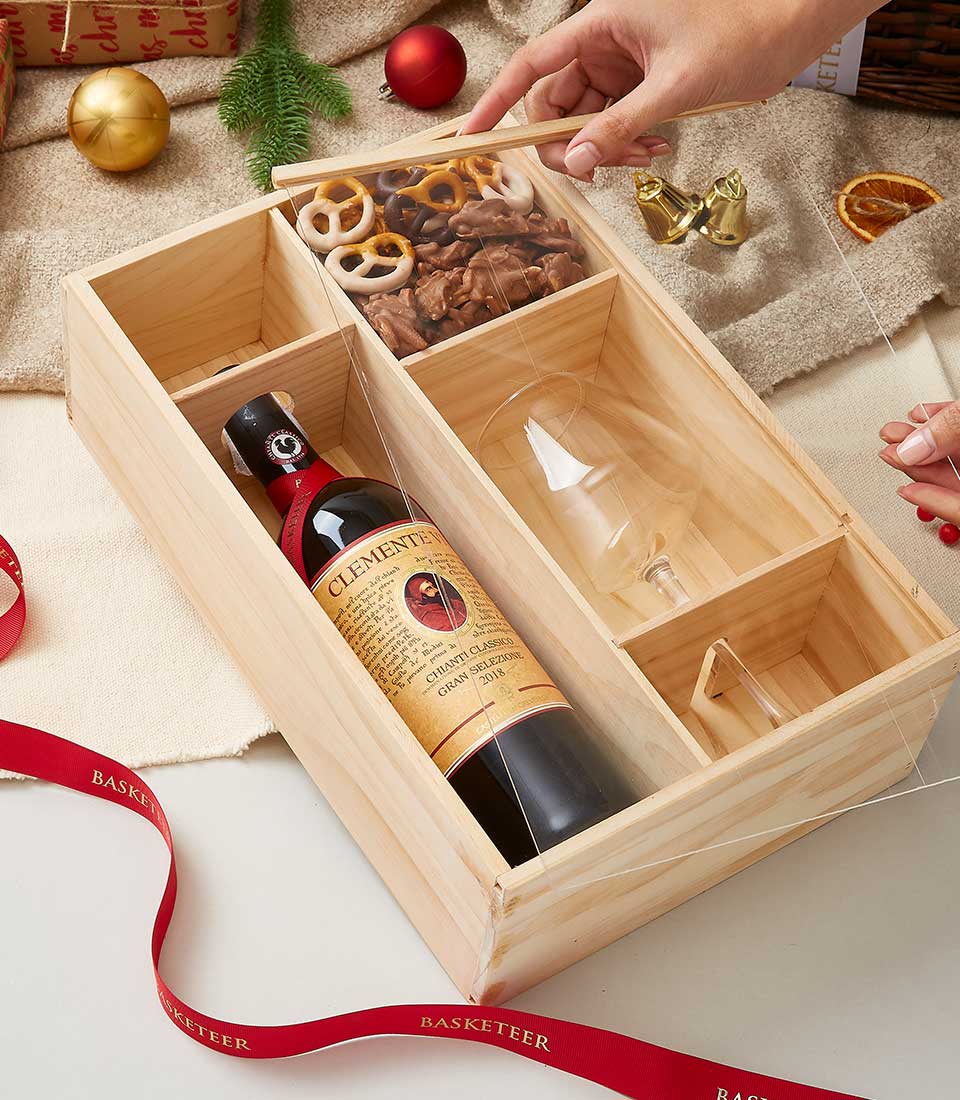 Wooden wine gift box with Chianti Classico red wine, wine glass, and chocolate-covered pretzels