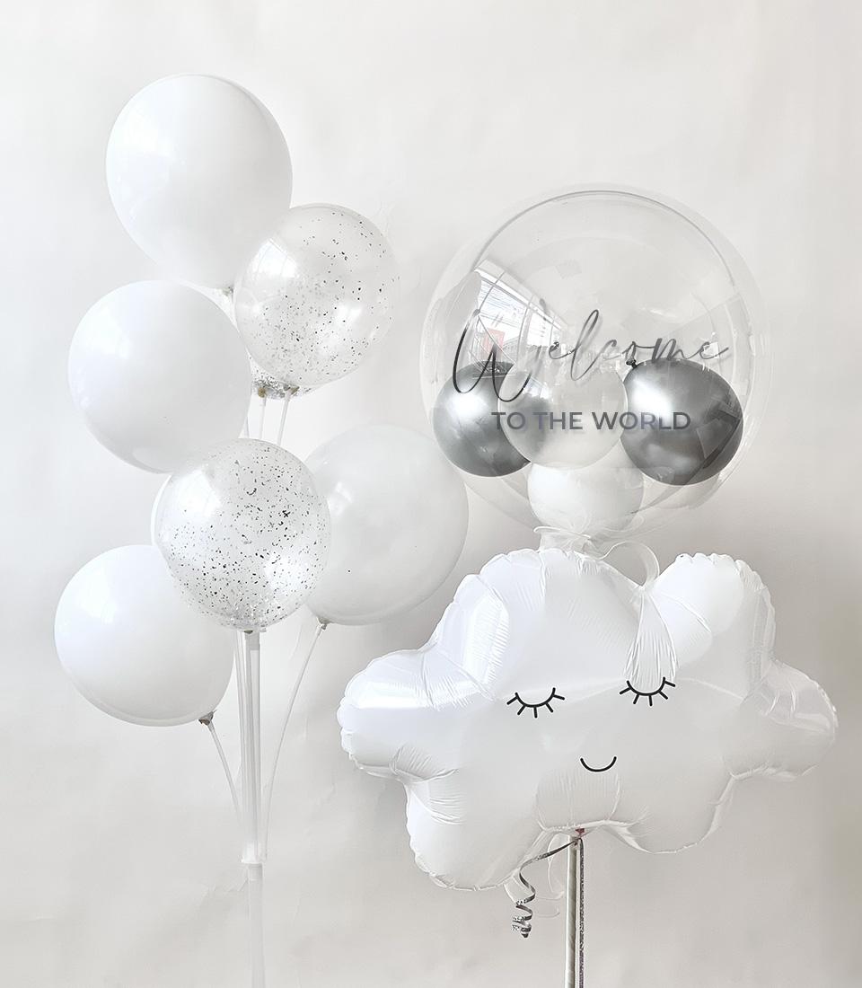Whimsical white and clear balloon arrangement with glitter, bubble balloon, and smiling cloud for new baby celebrations
