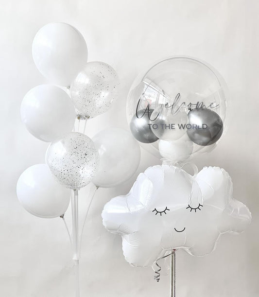 Whimsical white and clear balloon arrangement with glitter, bubble balloon, and smiling cloud for new baby celebrations