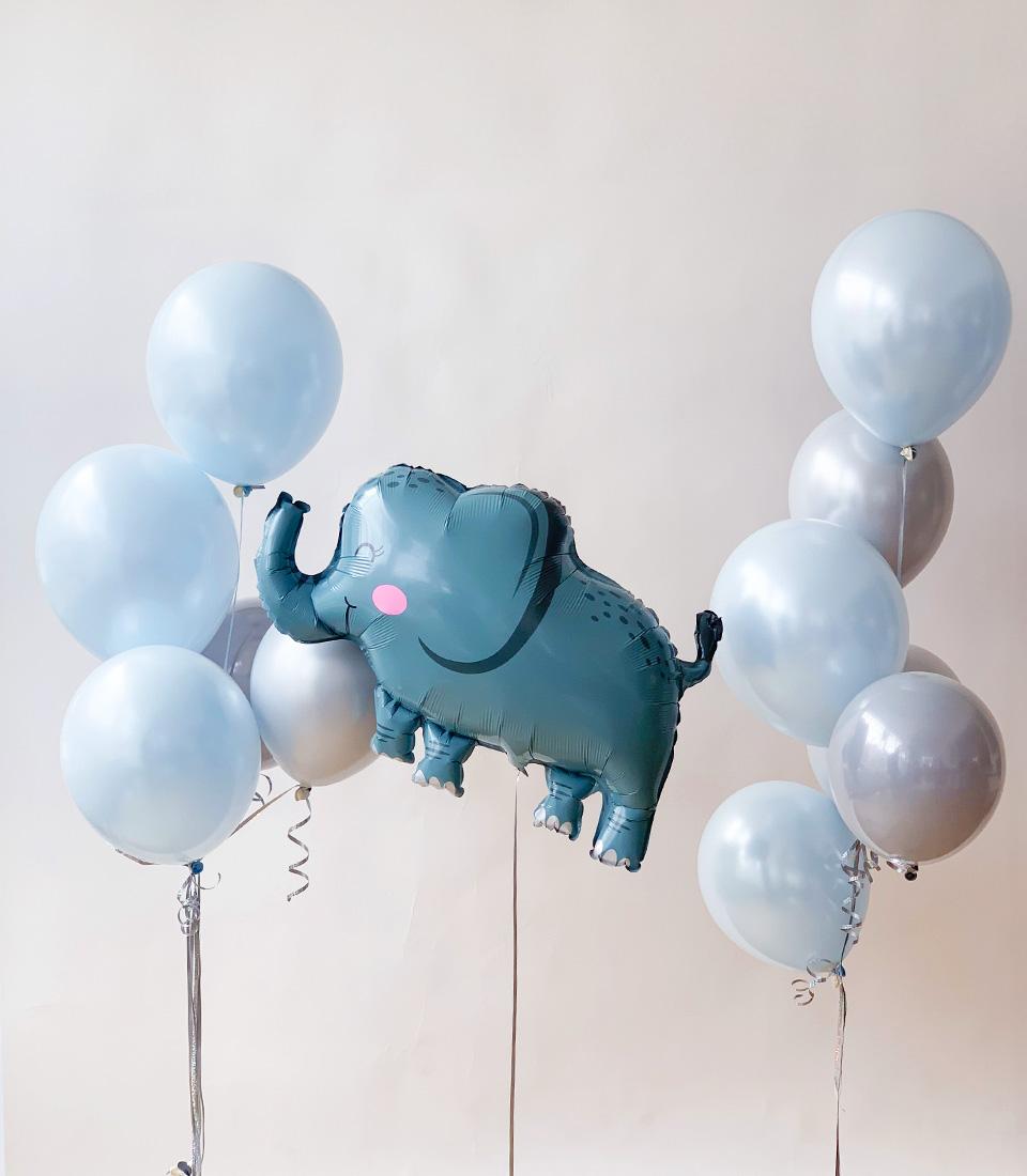 Teal elephant foil balloon with blue and silver latex balloons, tied with ribbons for baby birthday celebrations