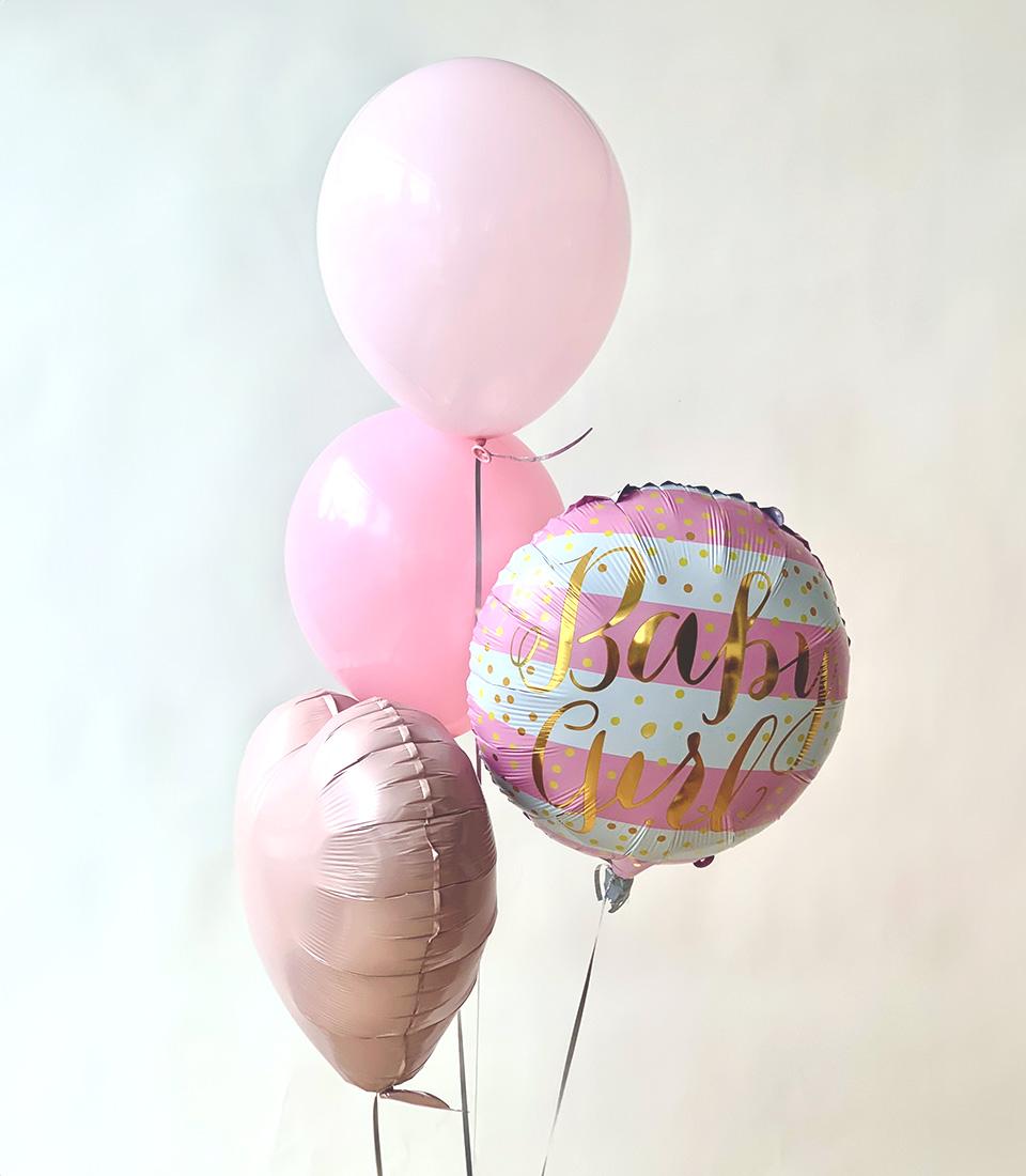Light pink and rose gold baby girl balloon bouquet with striped foil balloon and polka dot accents